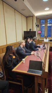 Kendrah sitting with others in a meeting.