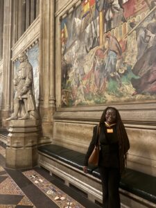 Kendrah smiling at the camera, posing in front of a painting in a museum.