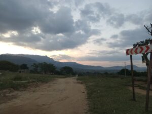 A view of a dirt road and a sunset.