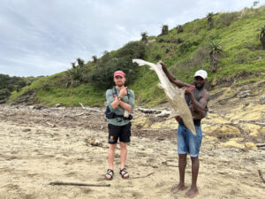 Mac and a friend after a hike, holding a large fish.
