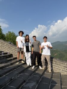Abzal and 3 friends smiling for a photo on stairs.