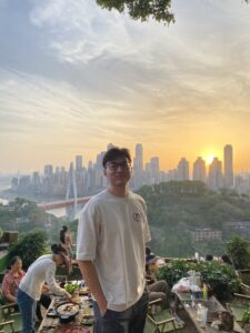 Abzal standing in front of a view of the city behind him.